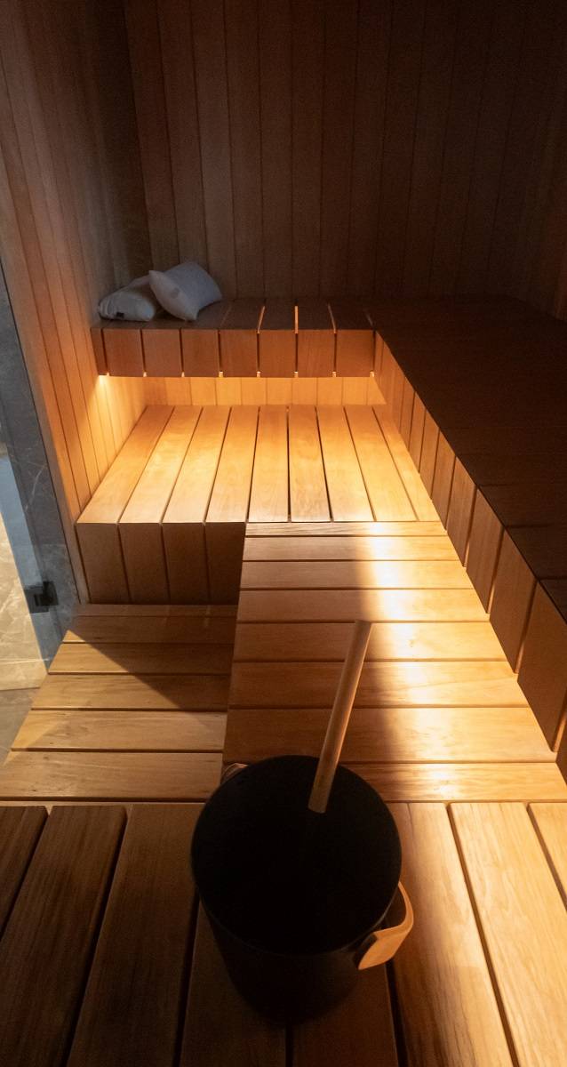 Una tira de LED de 7,2 W/m de tono cálido en perfil de aluminio montada en la parte inferior del asiento de una sauna.